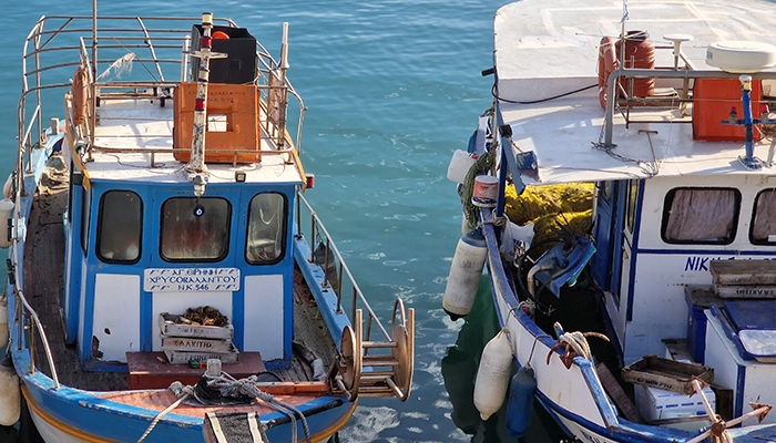 Traditional fishing boats at Heraklion port in Crete with calm sea, a safe and authentic place for tourists