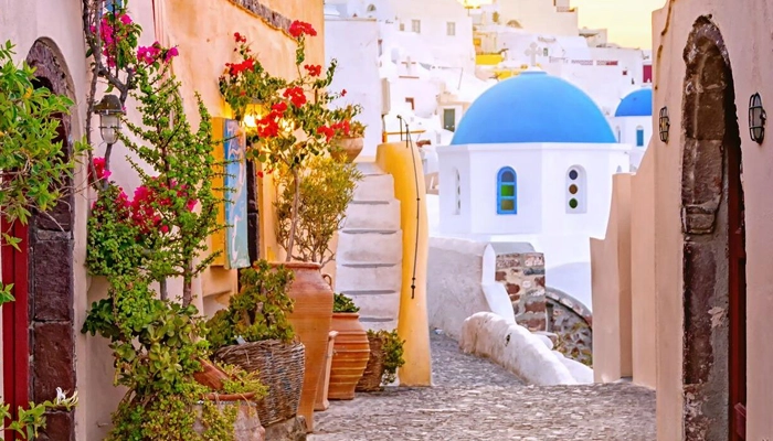 Santorini alley with blue dome church and traditional houses