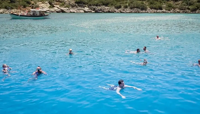 Swimming stop at Kolokytha beach during Spinalonga BBQ boat tour in Crete with Car and Travel