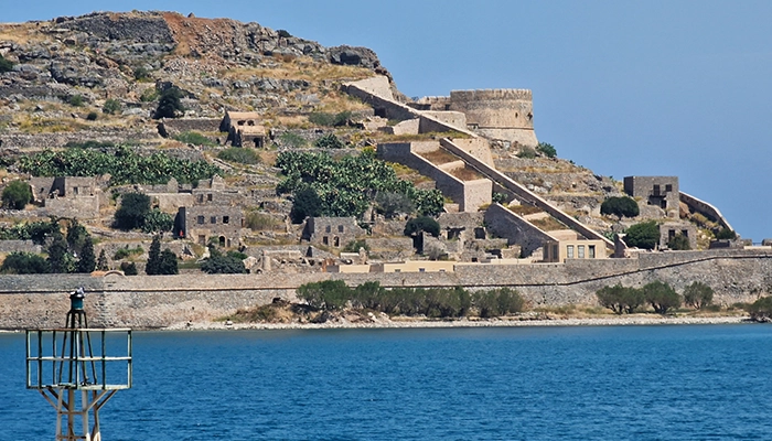 Spinalonga fortress in Crete close view with stone buildings and sea, a historic and safe destination for visitors