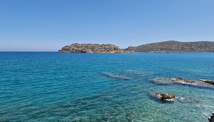 Spinalonga island near Agios Nikolaos Crete with calm sea and blue sky, a safe and scenic destination for tourists