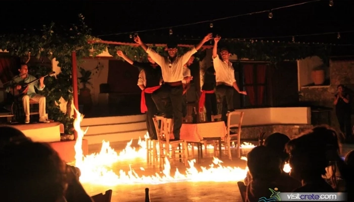 Cretan Night fire dance show with traditional dancers on table in Karouzanos village Crete