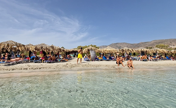 Sun umbrellas on Elafonisi beach with pink sand and turquoise sea Crete