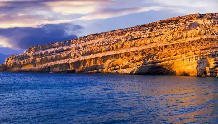 Matala beach rocks at sunset in Crete during Matala Odigitria excursion with Car and Travel